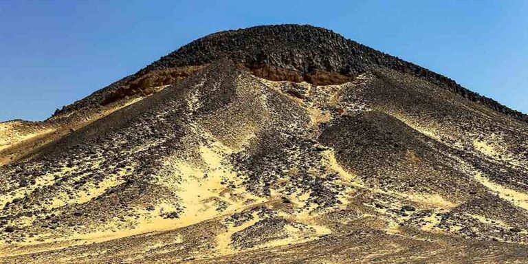 Dark volcanic hills and black stones scattered across Egypt’s Black Desert.